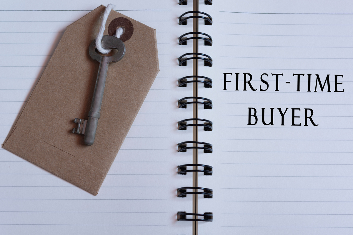 Text written on notebook with house key - First time buyer